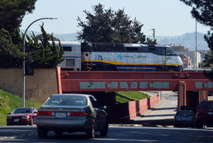 An Amtrak train passes over cars traveling on Macdonald Ave. as it departs the station in Richmond, Calif. on Monday, March 24, 2014. The tracks that carry